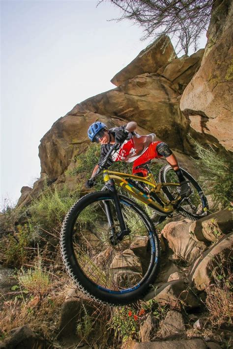 A Man Riding A Mountain Bike Up The Side Of A Cliff