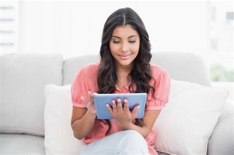 Premium Photo Content Cute Brunette Sitting On Couch Using Tablet