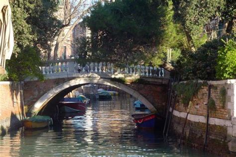 Bridge reflected in the tranquil waters of a Venetian canal | Venetian canals | Venice | Travel ...