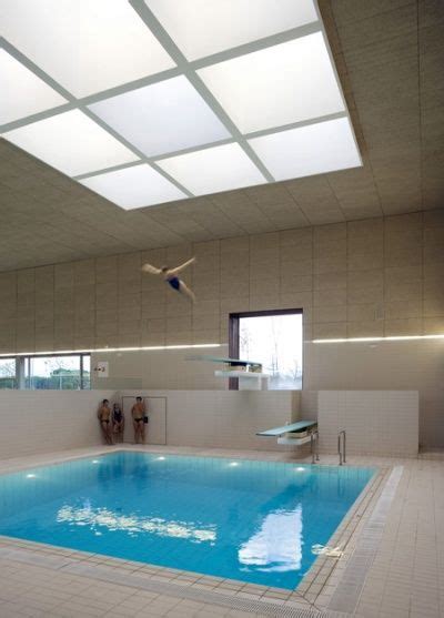 An Indoor Swimming Pool With Skylights And Tiled Floors