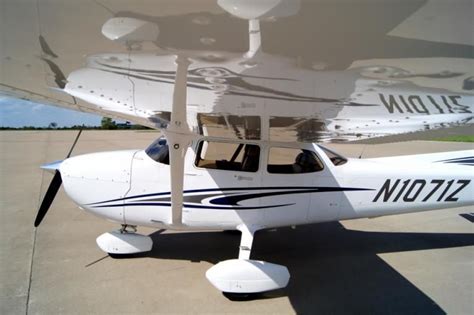 A Small White Airplane Sitting On Top Of An Airport Tarmac