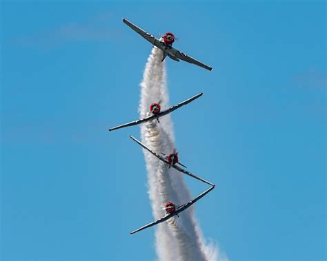 Premium Photo | Low angle shot of airplane stunts on an airshow