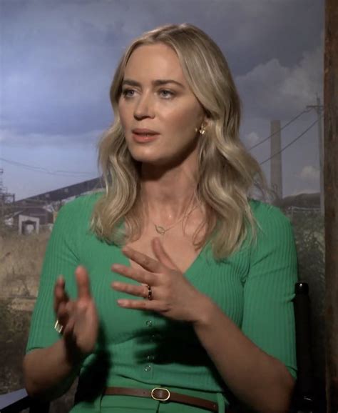 A Woman In A Green Dress Is Talking To Someone On The Television Screen