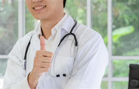 Smiling Male Doctor Showing Thumbs Up Sign Stock Photo At Vecteezy