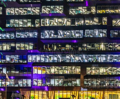 Multi Storey Office Building At Night With Worker Working Overtime