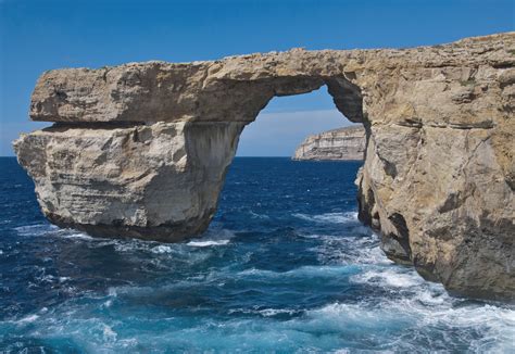 Lanscape Photography Of Arch Formed Gray Rock Over Body Of Water Malta