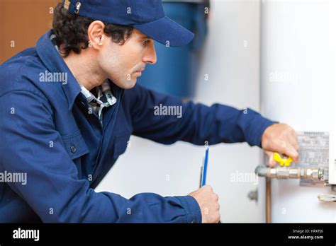 Plumber Repairing An Hot Water Heater Stock Photo Alamy