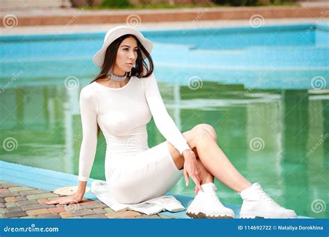 Beautiful Woman In Elegant Dress Brunette Lying By Blue Swimming Pool