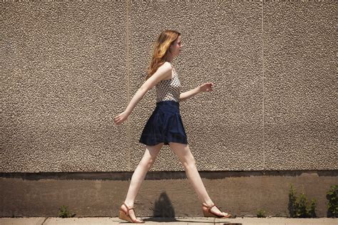 Side View Of Woman Walking On Footpath Stock Photo