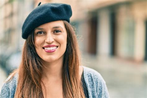 Joven mujer latina con estilo francés de pie en la ciudad Foto Gratis