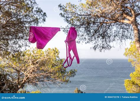 Wet Swimsuit On The Rope With Pins On The Beach Orange Bikini Bottom Drying On Clothesline On