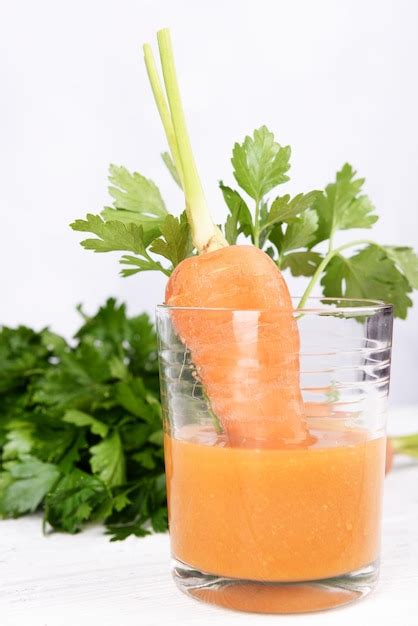 Vaso De Jugo De Zanahoria Con Zanahoria Fresca Y Perejil En La Mesa