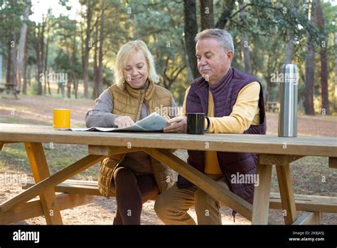Mature Couple Of Hikers Sitting In A Picnic Area Planning A Route With A Map Stock Photo Alamy