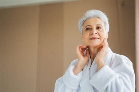 Premium Photo Mature Adult Old Woman Applying Nourishing Anti Age Face Cream Doing Daily