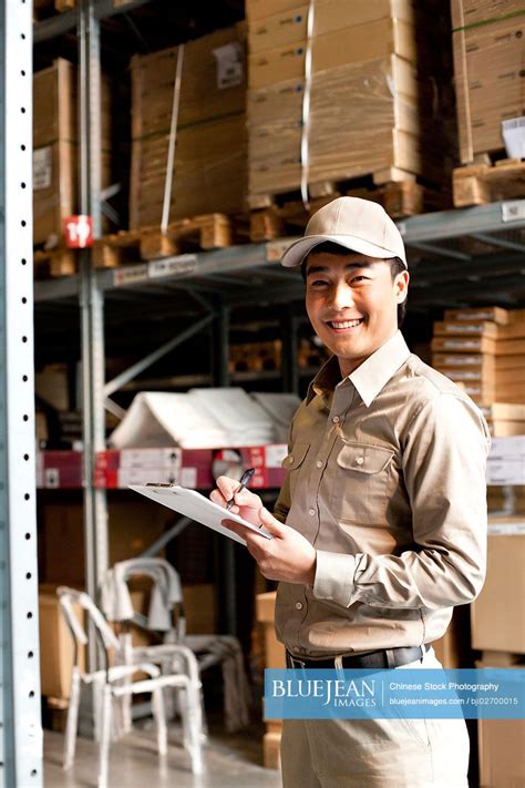 Male Chinese Warehouse Worker With Clipboard High Res Stock Photo For