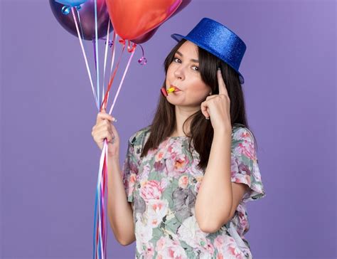 Impresionada Joven Hermosa Mujer Vistiendo Gorro De Fiesta Sosteniendo