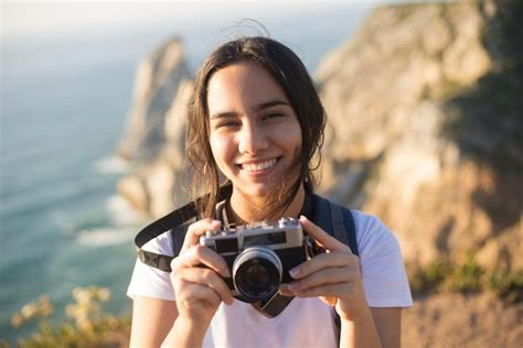 Retrato de una adolescente con cámara sonriendo Foto Gratis