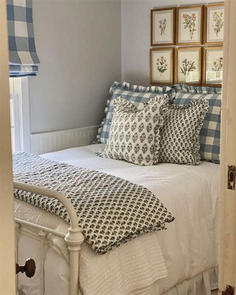 A White Bed Topped With Lots Of Pillows Next To Framed Pictures On The