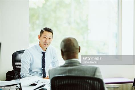 Smiling Businessman In Discussion With Client In Office High Res Stock