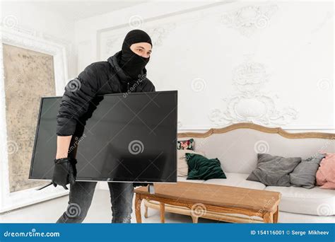 Man Burglar Stealing Tv Set From House Thief With Black Balaclava