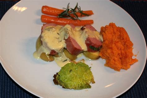 A White Plate Topped With Meat And Veggies Next To Mashed Carrots