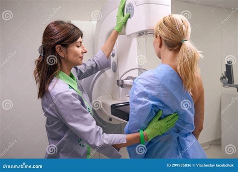 Professional Radiographer Preparing Client For Diagnostic Mammogram