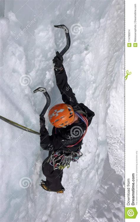 Male Ice Climber On A Steep Frozen Waterfall On A Beautiful Winter Day