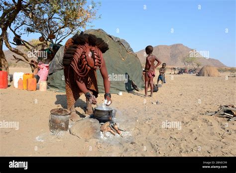 Himba Woman Cooking Maize Flour On An Open Fireplace Marienfluss