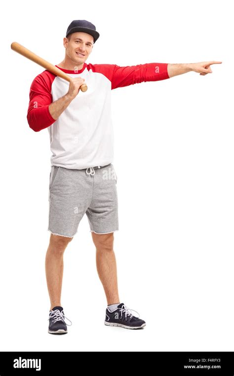 Full Length Portrait Of A Young Man Holding A Baseball Bat And Pointing