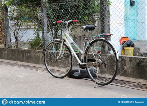 Bicicleta Velha Que Estaciona Na Rua Ao Lado Da Cerca Do Ferro Foto De