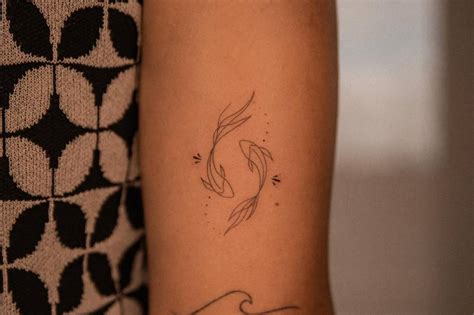 Fine Line Style Two Opposite Fish Tattoo Located On The