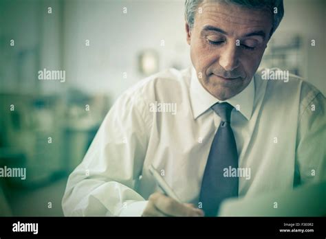 Mature Businessman Writing In Office Stock Photo Alamy