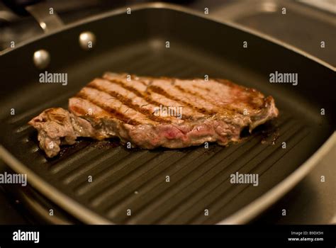 A Sirloin Steak Frying In A Griddle Pan Stock Photo Alamy