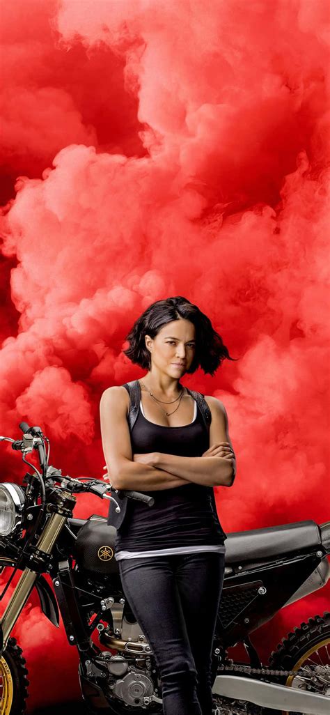 Download A Woman Standing Next To A Motorcycle Wallpaper