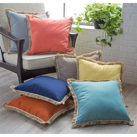 Four Different Colored Pillows Sitting Next To Each Other