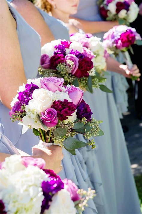 The Bridesmaids Are Holding Their Bouquets With Purple And White Flowers