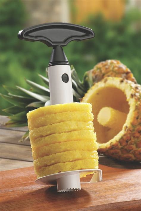 A Pineapple Slicer On A Wooden Table Next To A Sliced Pineapple