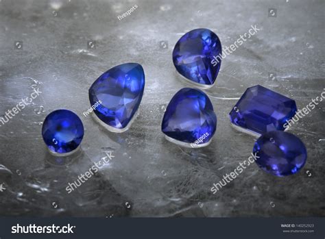 Different Cuts Of Tanzanite Isolated On Grey Ice Background Stock