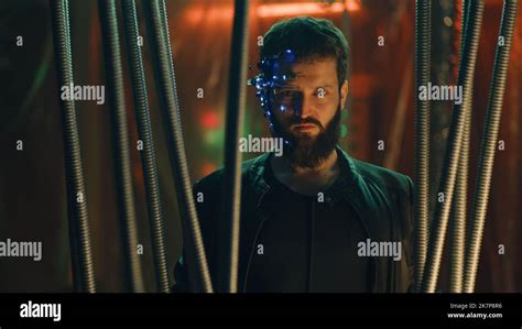 Un jeune gars de brunette de style Cyberpunk se tient derrière les tiges noires suspendues Port