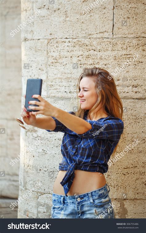 Young Attractive Girl Hipster Making Fun Self Portrait On A Cellphone