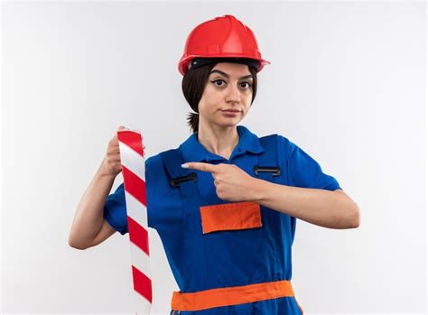 Contento mirando a la cámara joven constructor mujer en uniforme