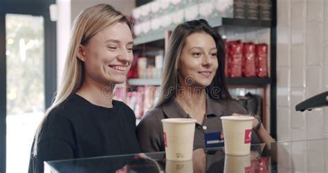 Bartender Serves Two Beautiful Girls With Coffee In The Cafe Payment