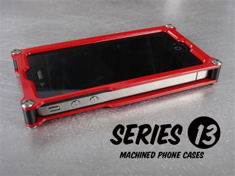 A Red Cell Phone Sitting On Top Of A Metal Table With The Words Series 13 Attached To It