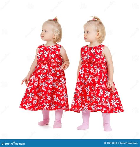Two Identical Twin Girls in Red Dresses Looking Stock Photo - Image of