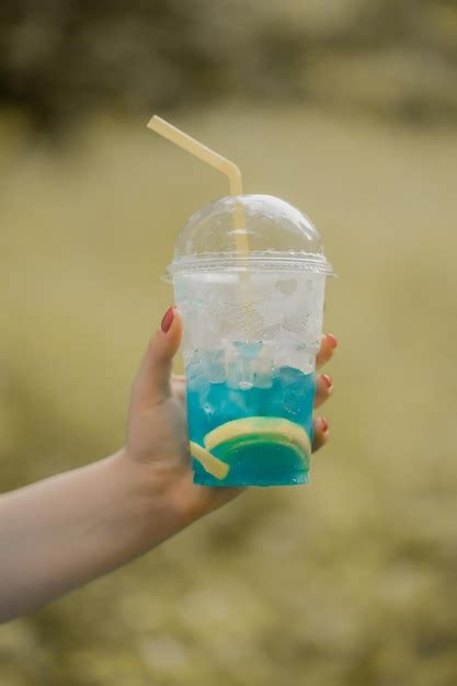 Premium Photo Woman Hand Holding A Glass With Lemonade Or Mojito