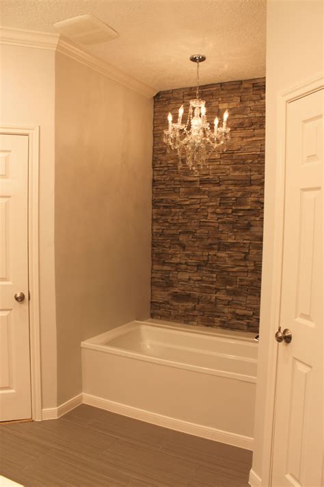 My Tub With Faux Stone Wall Accent Wall And Chandelier Trendy Bathroom