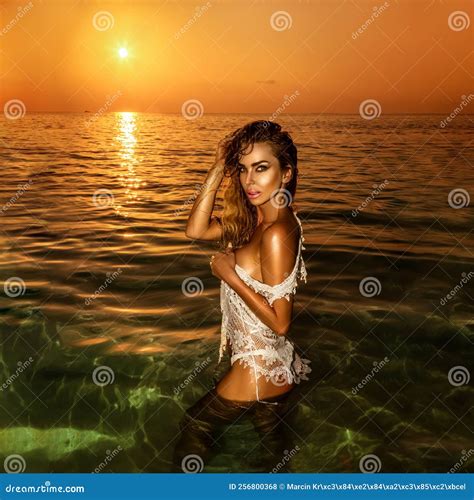 Woman In Bikini Is Posing In Ocean On Sunset On The Maldives Island