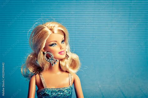 Blond Barbie Doll In Blue Dress Over Blue Background Stock Photo