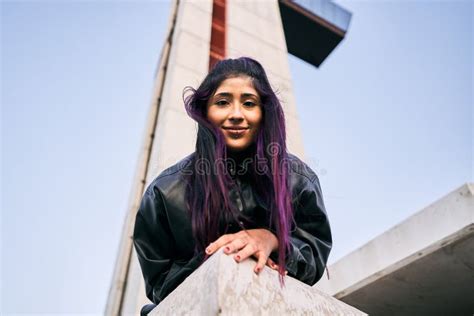 Brunette Latina Girl With Pink Dyed Hair Looking At Camera Calm And Relaxed Lying On The Floor