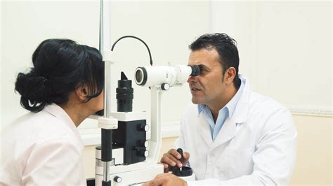 An experienced doctor looks at the device for testing the patients vision 35314301 Stock Video ...